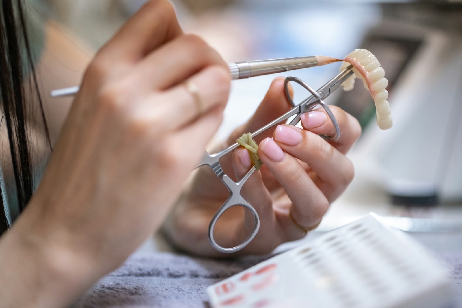 A technician finishing a dental prosthesis by hand
