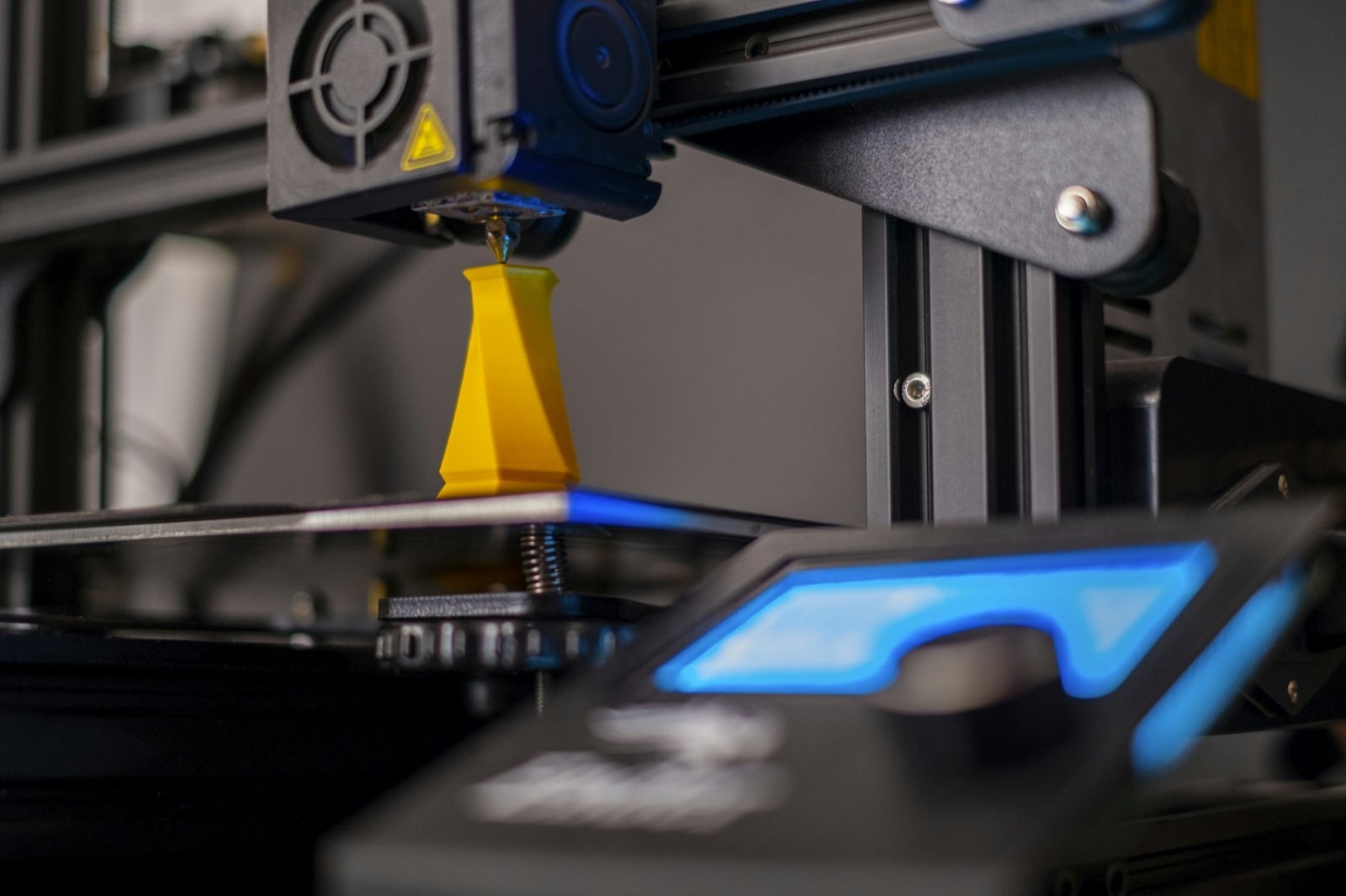 A 3D printer at work under blue light